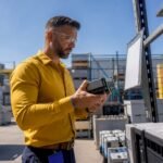 Integrator inspecting automation parts in warehouse